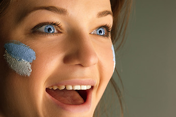 Image showing Portrait of a woman with the flag of the Argentina painted on her face.