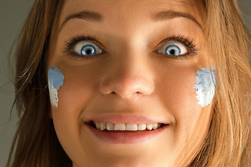 Image showing Portrait of a woman with the flag of the Argentina painted on her face.