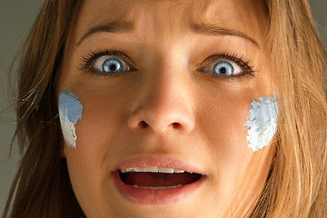 Image showing Portrait of a woman with the flag of the Argentina painted on her face.