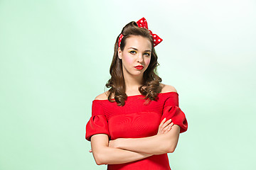 Image showing Beautiful young woman with pinup make-up and hairstyle. Studio shot on white background