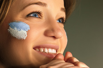 Image showing Portrait of a woman with the flag of the Argentina painted on her face.