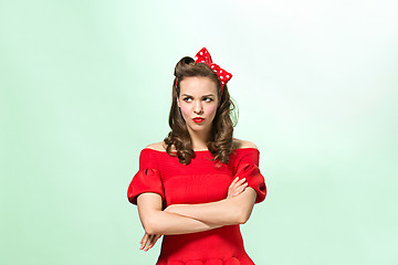 Image showing Beautiful young woman with pinup make-up and hairstyle. Studio shot on white background