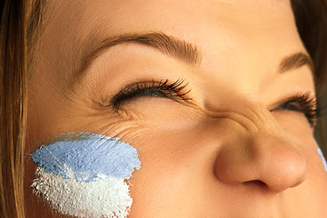 Image showing Portrait of a woman with the flag of the Argentina painted on her face.