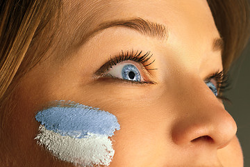 Image showing Portrait of a woman with the flag of the Argentina painted on her face.