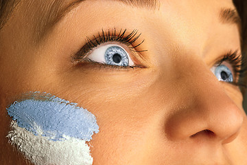 Image showing Portrait of a woman with the flag of the Argentina painted on her face.