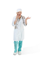 Image showing Beautiful young woman in white coat posing at studio. Full length studio shot isolated on white.