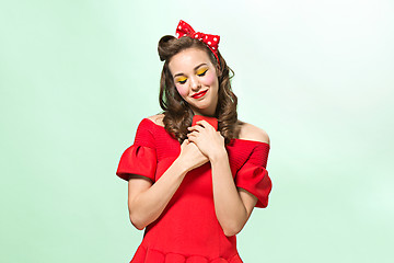 Image showing Beautiful young woman with pinup make-up and hairstyle. Studio shot on white background