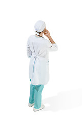 Image showing Beautiful young woman in white coat posing at studio. Full length studio shot isolated on white.