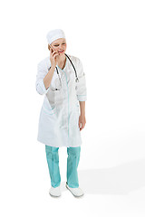 Image showing Beautiful young woman in white coat posing at studio. Full length studio shot isolated on white.