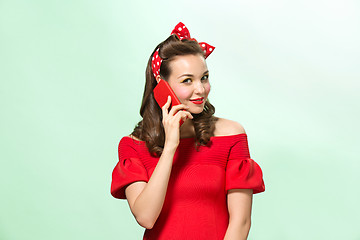 Image showing Beautiful young woman with pinup make-up and hairstyle. Studio shot on white background