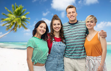 Image showing happy friends hugging over beach background