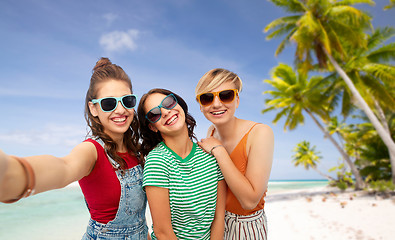 Image showing happy teenage girls taking selfie over beach