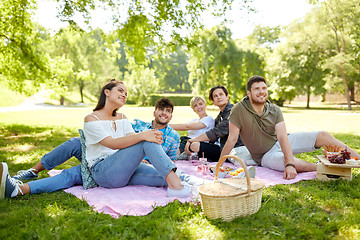 Image showing happy friends with drinks at picnic in summer park