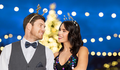 Image showing couple with party props over christmas tree lights