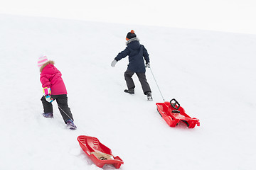 Image showing kids with sleds climbing snow hill in winter