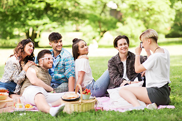 Image showing friends photographing at picnic in summer park