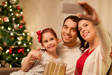 Image showing happy family with christmas present at home