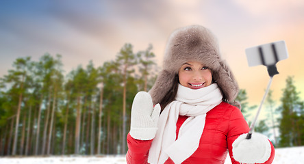 Image showing happy woman taking selfie over winter forest