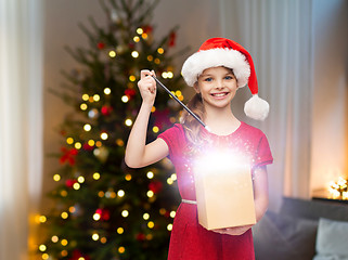 Image showing smiling girl with christmas gift and magic wand