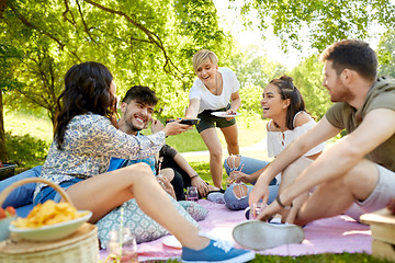 Image showing friends with drinks and food at picnic in park