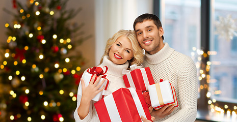 Image showing happy couple with christmas gifts at home