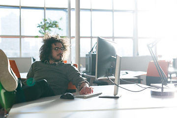 Image showing businessman sitting with legs on desk