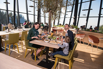 Image showing Young parents enjoying lunch time with their children