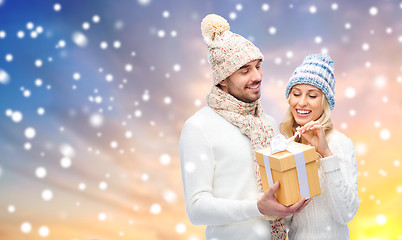 Image showing smiling couple in winter clothes with gift box