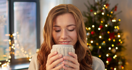 Image showing happy woman with cup of tea or coffee on christmas