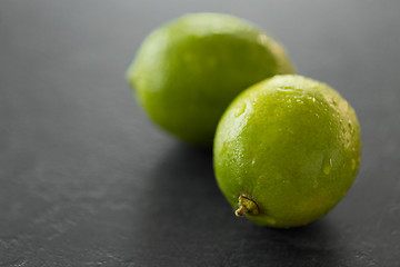 Image showing close up of whole limes on slate table top