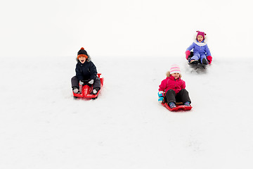 Image showing kids sliding on sleds down snow hill in winter