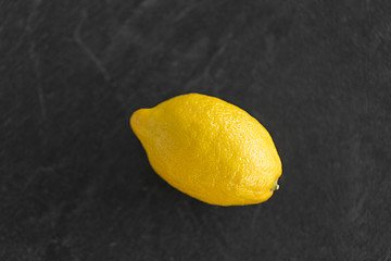 Image showing close up of whole lemon on slate table top