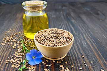 Image showing Flaxen brown seed in bowl with oil on dark board