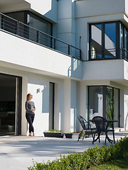 Image showing women using tablet computer in front of luxury home villa