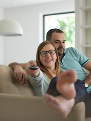 Image showing Young couple on the sofa watching television