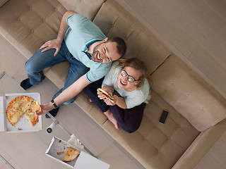 Image showing couple eating pizza in their luxury home villa