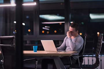 Image showing man working on laptop in dark office