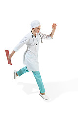 Image showing Beautiful young woman in white coat running at studio. Full length studio shot isolated on white.