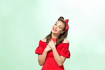 Image showing Beautiful young woman with pinup make-up and hairstyle. Studio shot on white background