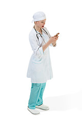 Image showing Beautiful young woman in white coat posing at studio. Full length studio shot isolated on white.