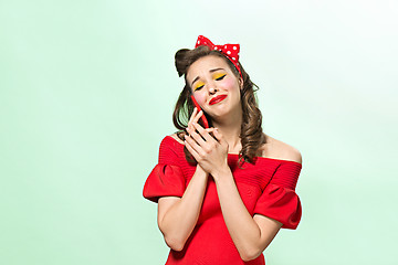 Image showing Beautiful young woman with pinup make-up and hairstyle. Studio shot on white background