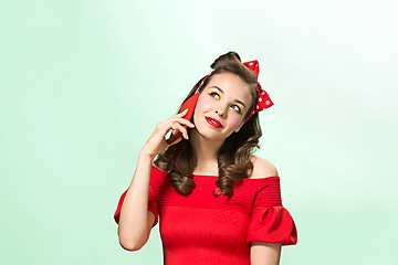 Image showing Beautiful young woman with pinup make-up and hairstyle. Studio shot on white background