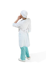 Image showing Beautiful young woman in white coat posing at studio. Full length studio shot isolated on white.