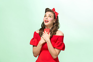 Image showing Beautiful young woman with pinup make-up and hairstyle. Studio shot on white background