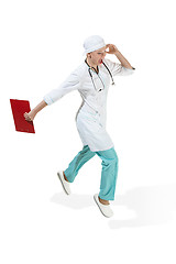 Image showing Beautiful young woman in white coat running at studio. Full length studio shot isolated on white.