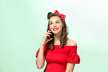 Image showing Beautiful young woman with pinup make-up and hairstyle. Studio shot on white background