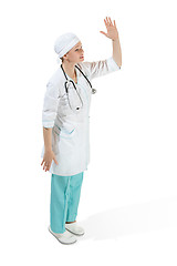 Image showing Beautiful young woman in white coat posing at studio. Full length studio shot isolated on white.