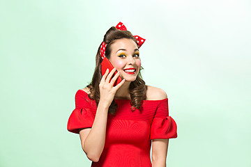 Image showing Beautiful young woman with pinup make-up and hairstyle. Studio shot on white background