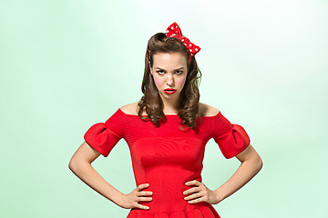 Image showing Beautiful young woman with pinup make-up and hairstyle. Studio shot on white background