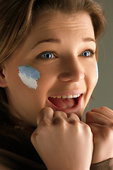 Image showing Portrait of a woman with the flag of the Argentina painted on her face.